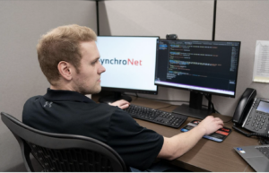 Synchro-Net employee at desk.